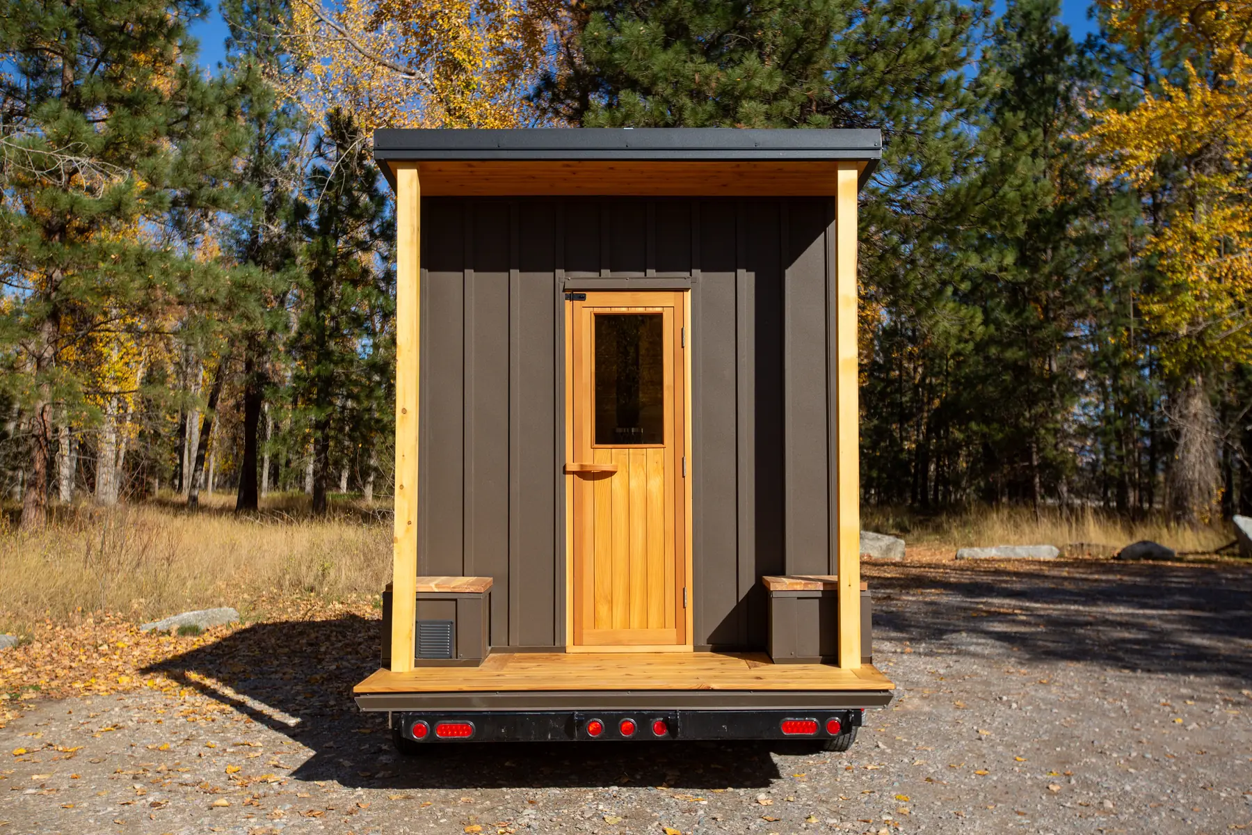 Front of the Mobile 10 with a cedar door and a covered porch on the trailer