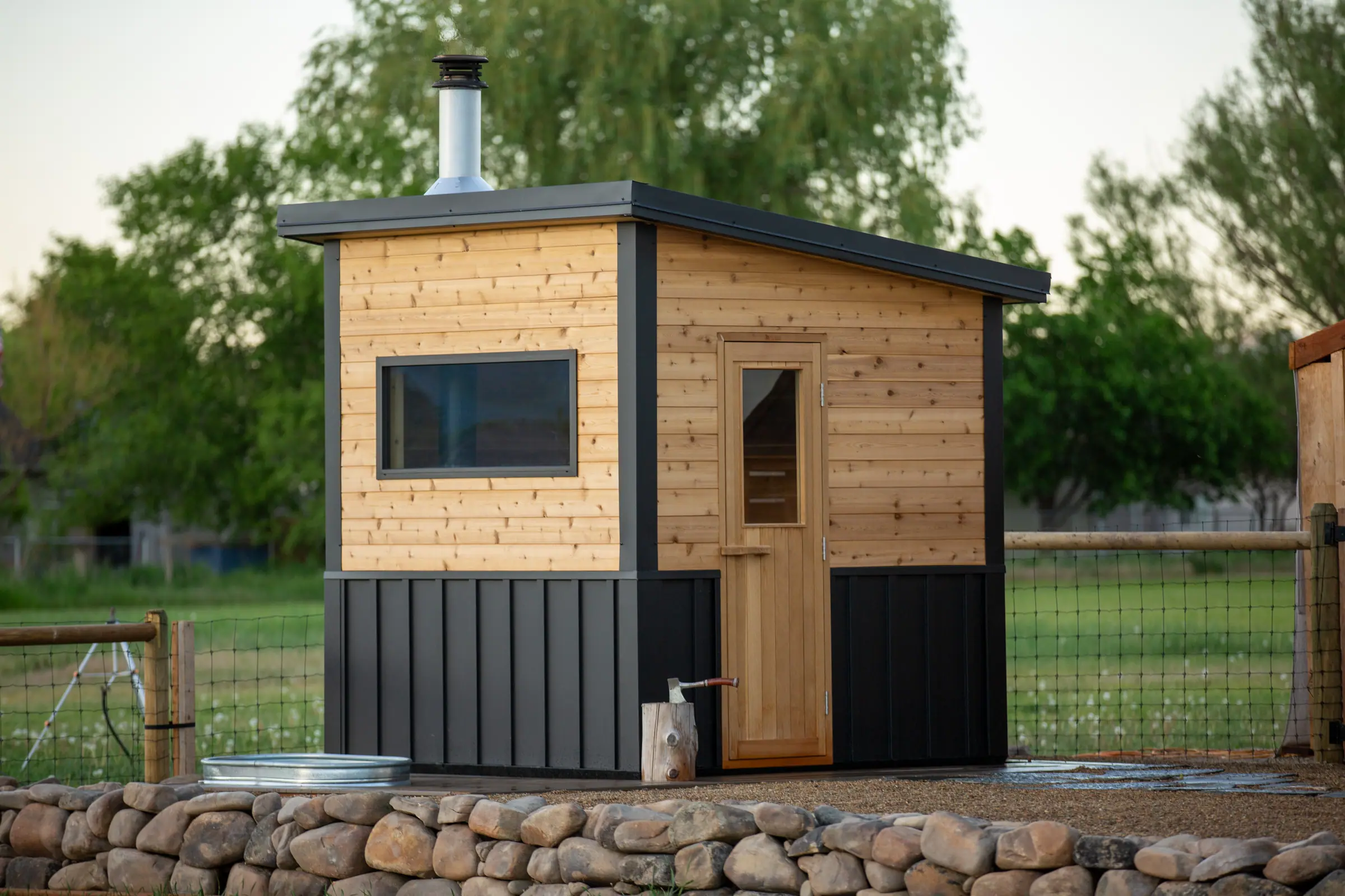 Cedar and black sauna on a stone-edged patio