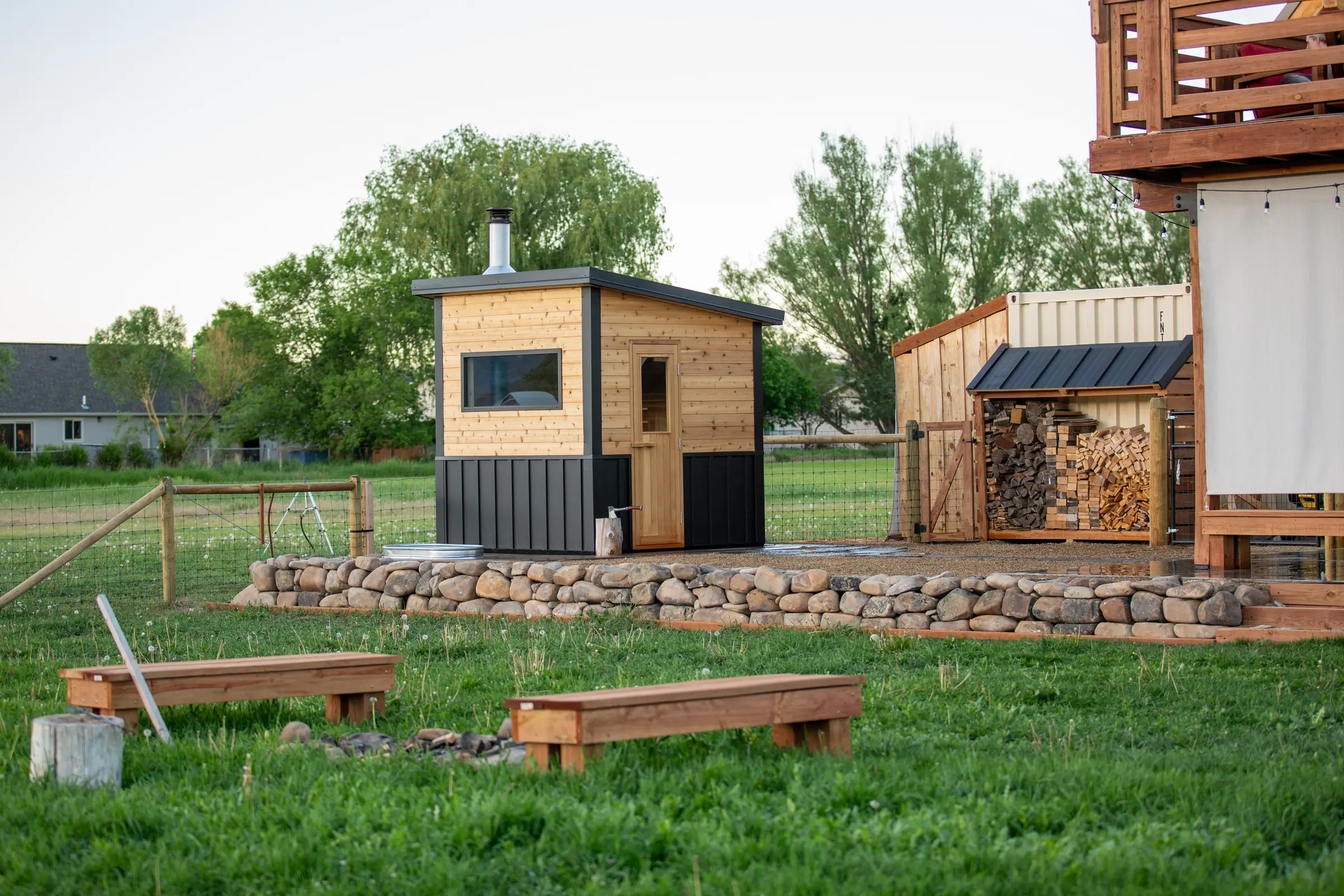 Cedar and black sauna in a wide backyard