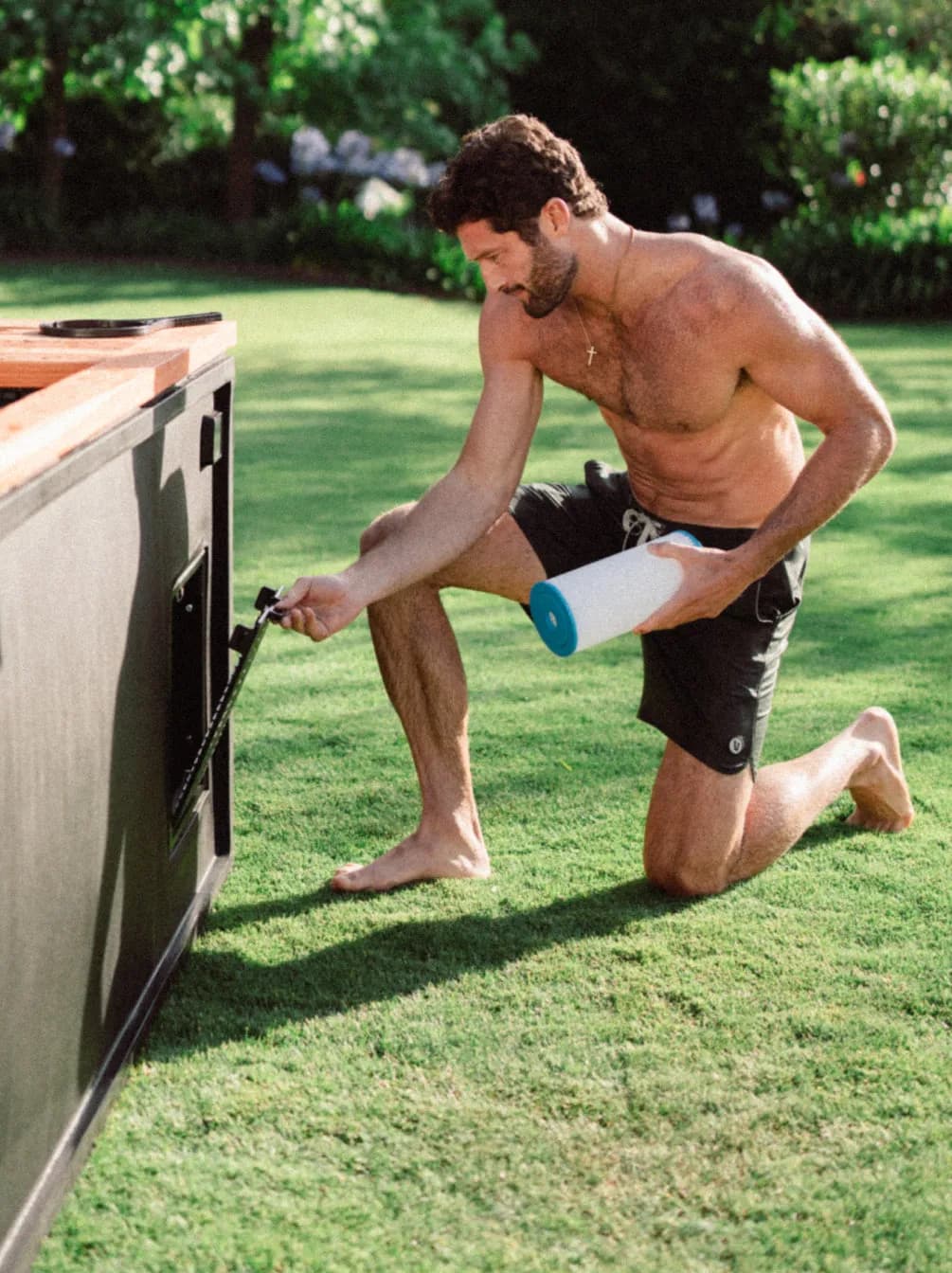 Man kneeling on a lawn, sliding a filter into the side of a black Cold Stoic