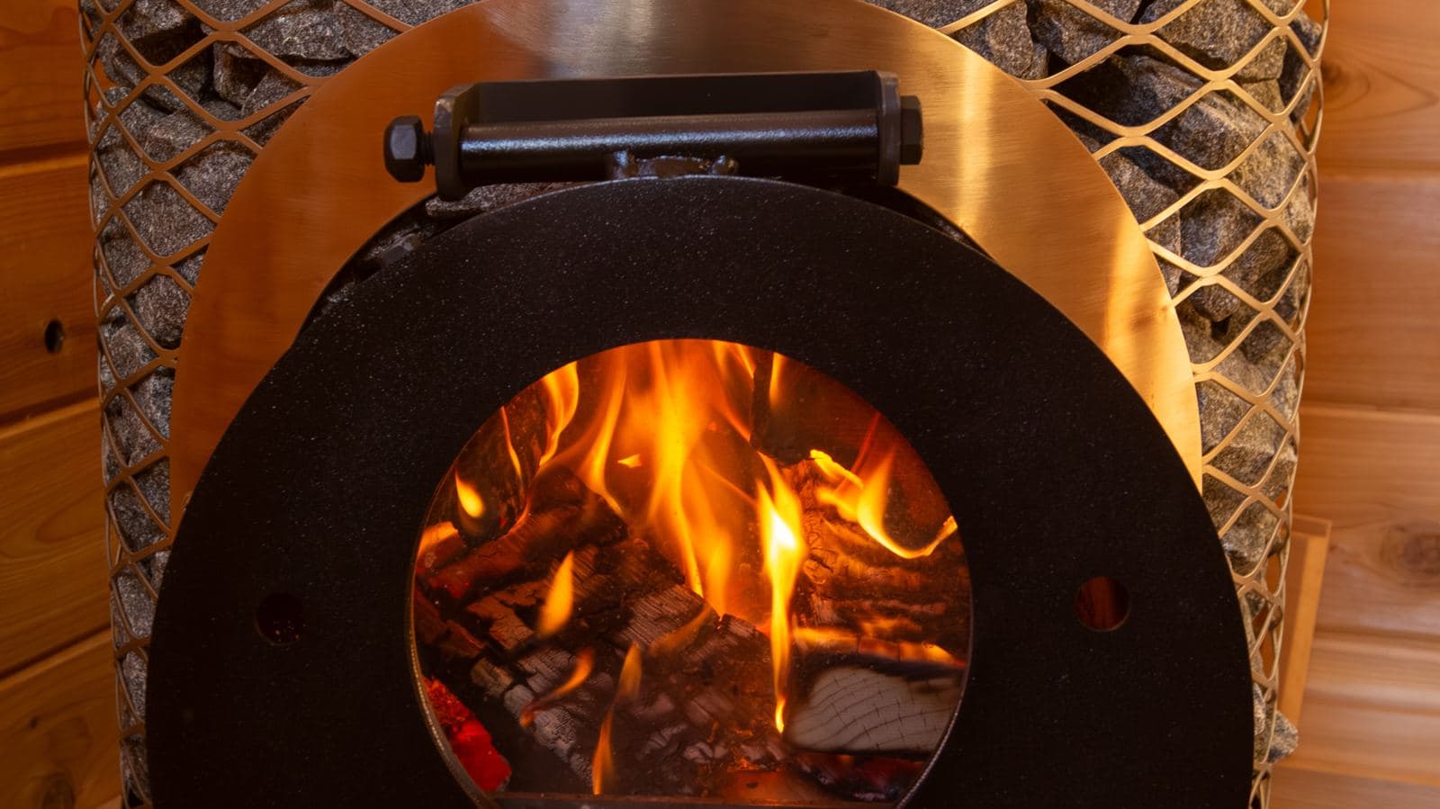 Fire burning inside a wood-fired IKI sauna stove