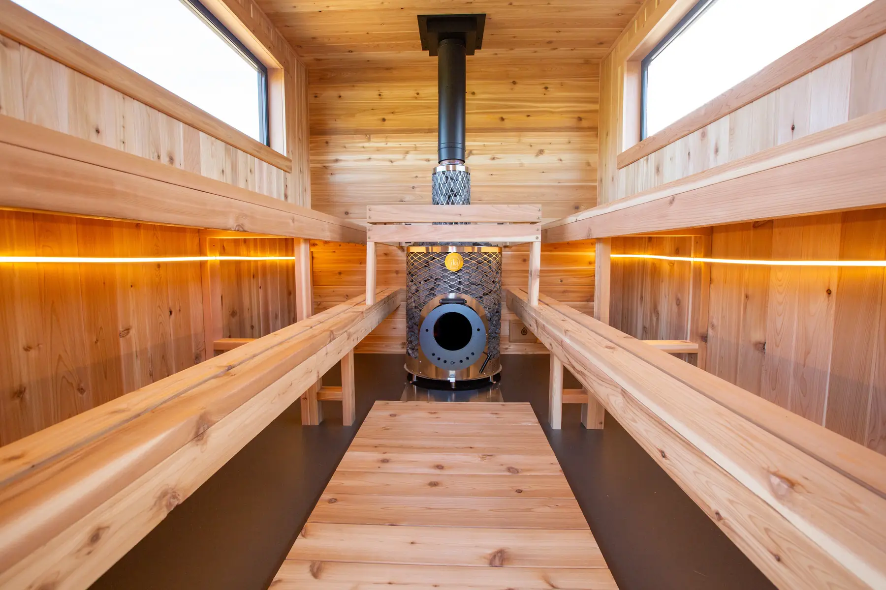 Inside the Mobile 10: IKI Original Plus wood fired stove between lit two-tier cedar benches