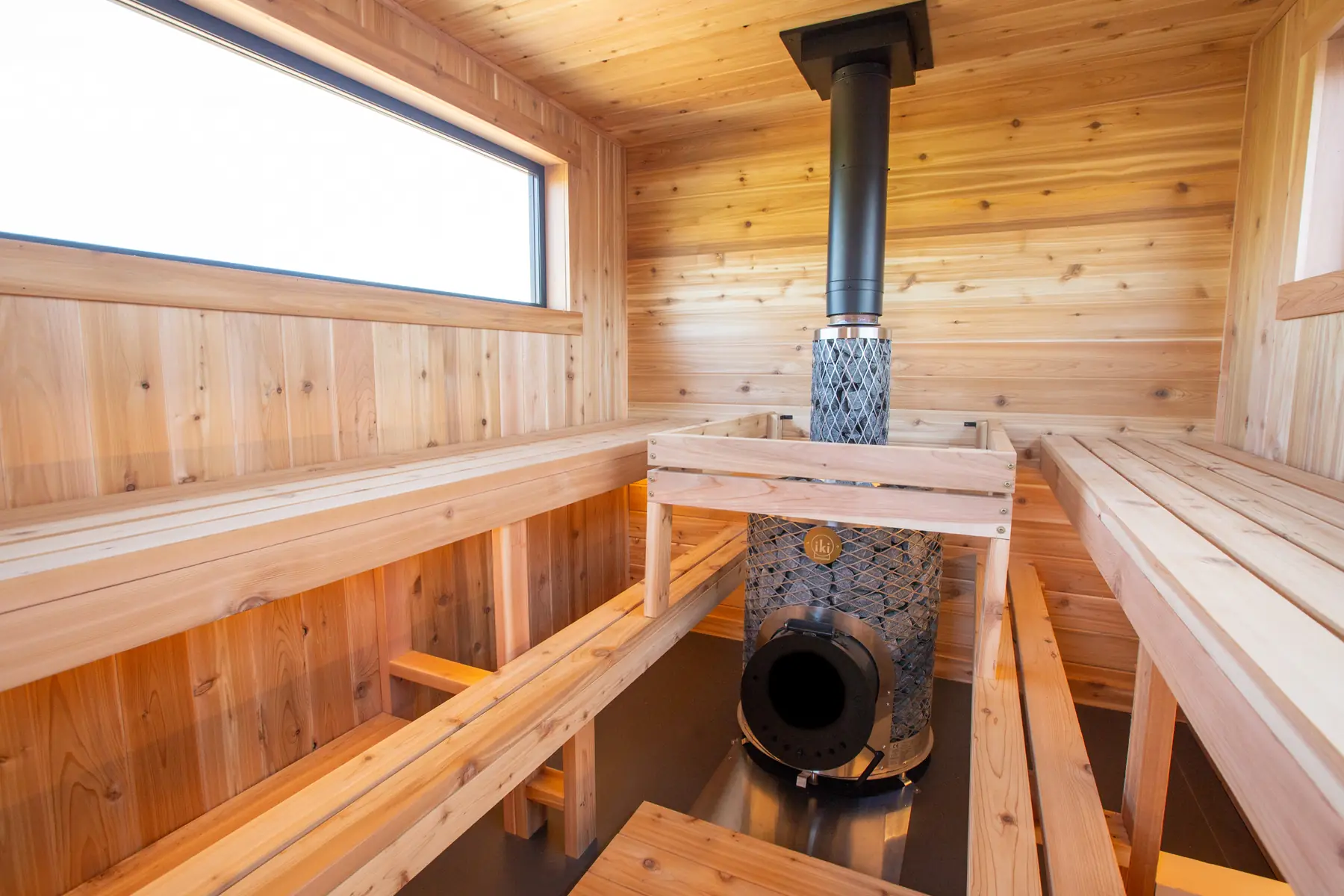 Wood stove with its stone cage between the cedar benches
