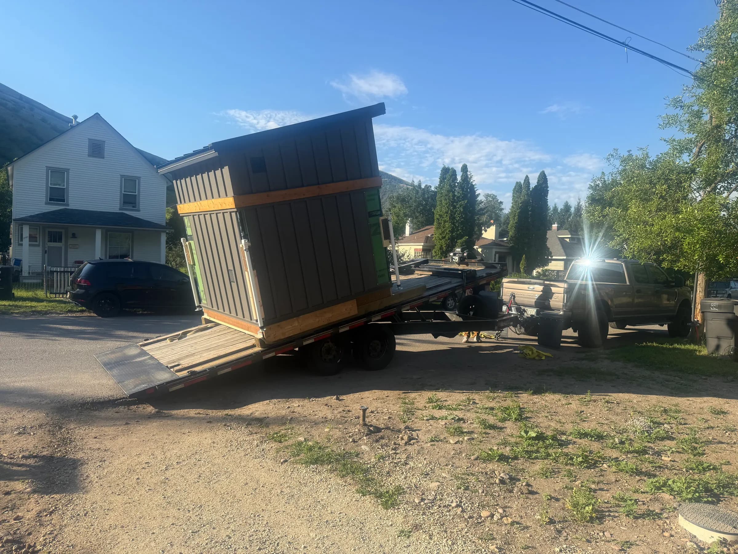 Sauna tilting off a trailer onto a driveway