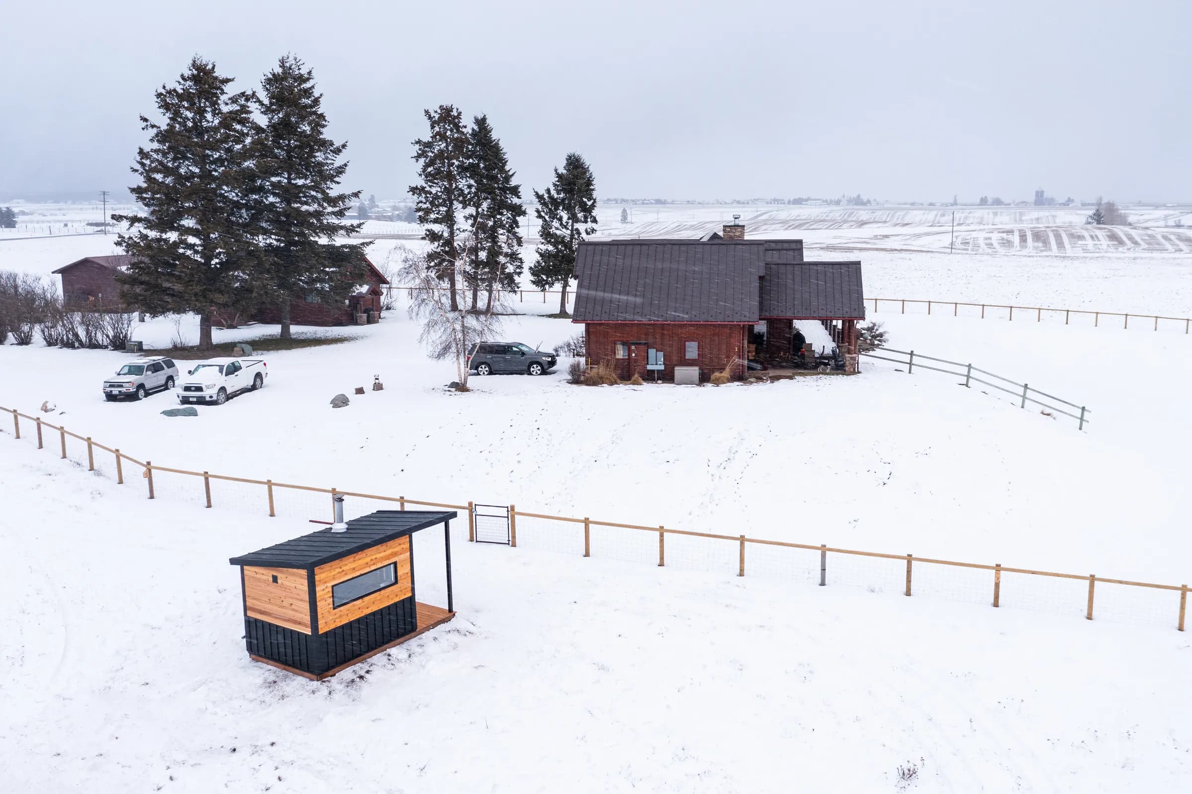Aerial view of the Model N in a snowy pasture near a ranch house
