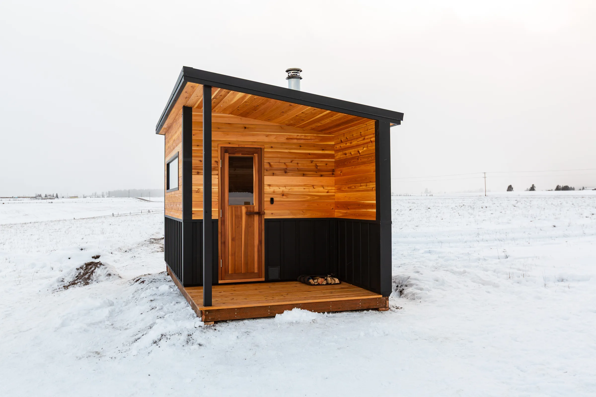 Model N with a covered porch and cedar door in deep snow