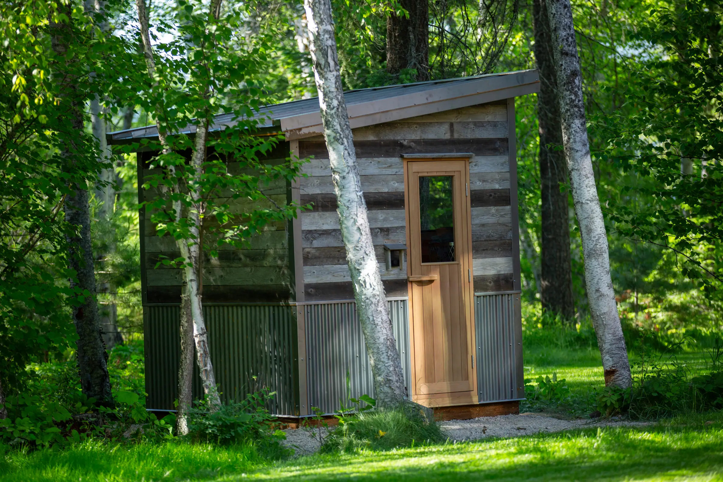 Side of a reclaimed-wood sauna with a metal base