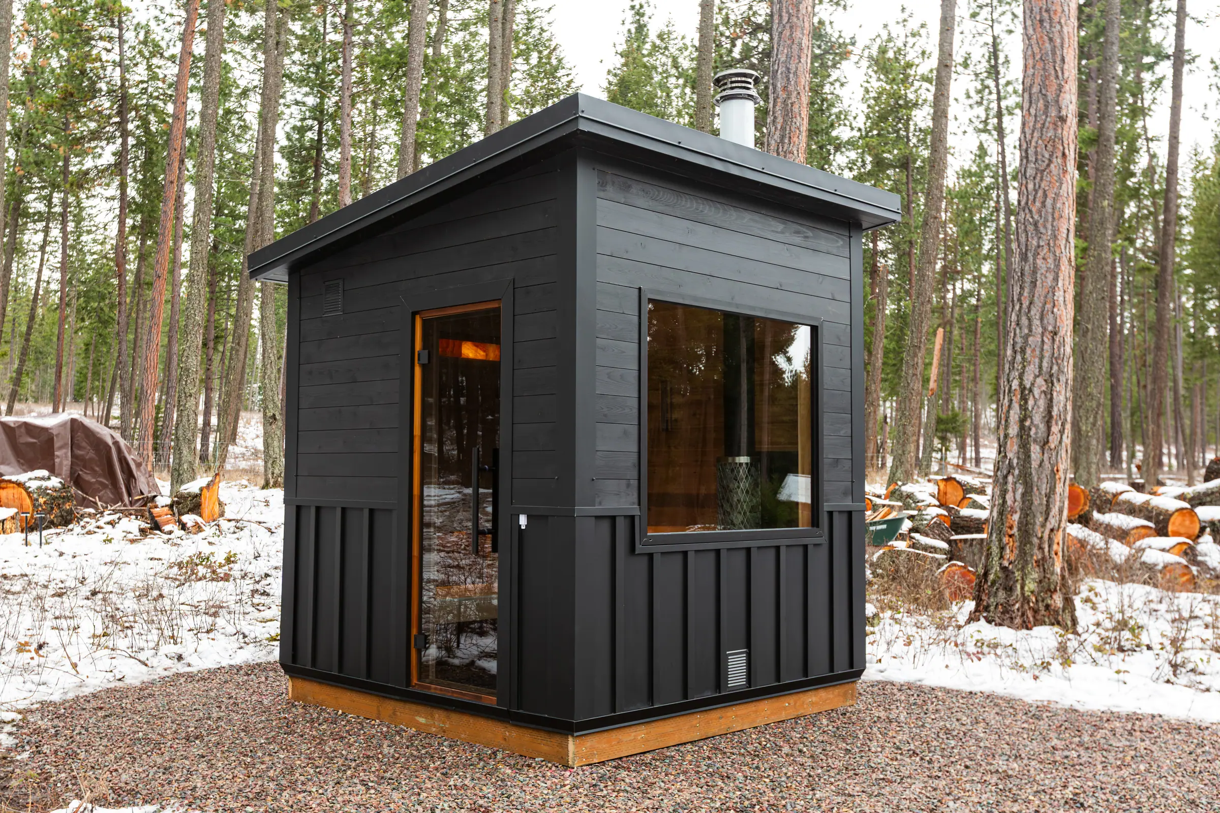 Black sauna with a picture window in deep snow