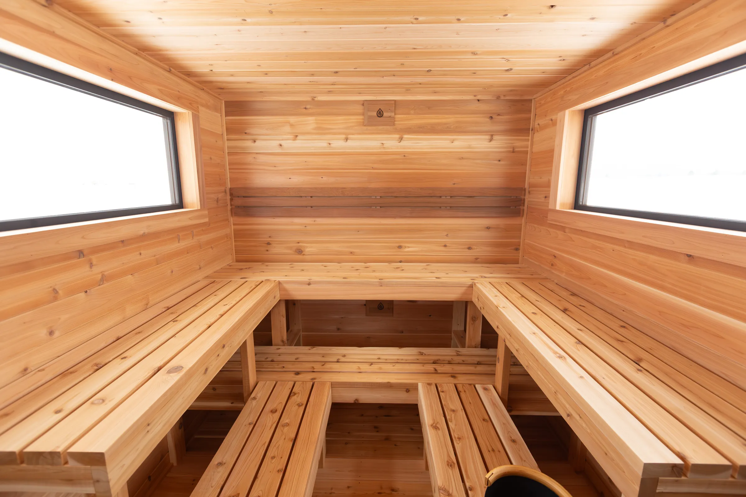 Cedar benches wrapping three walls under two windows