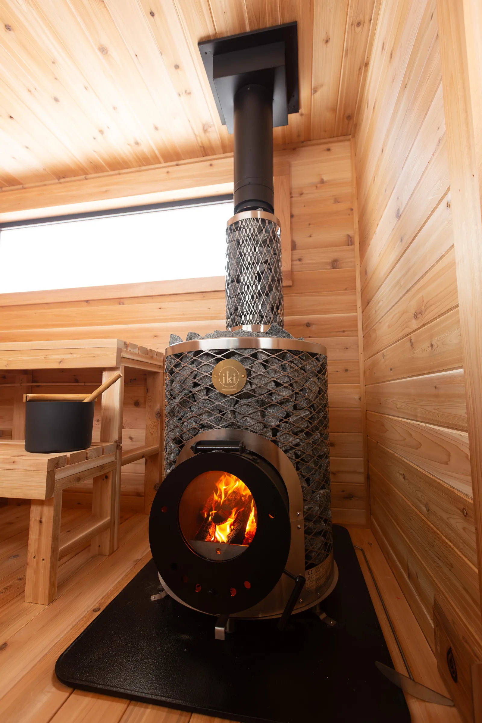 Wood-fired IKI stove with its stone cage and chimney
