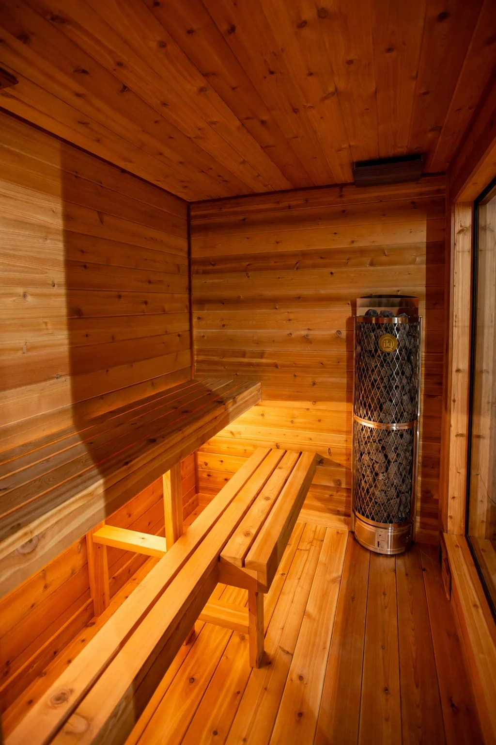 Cedar benches and an electric heater inside an indoor sauna