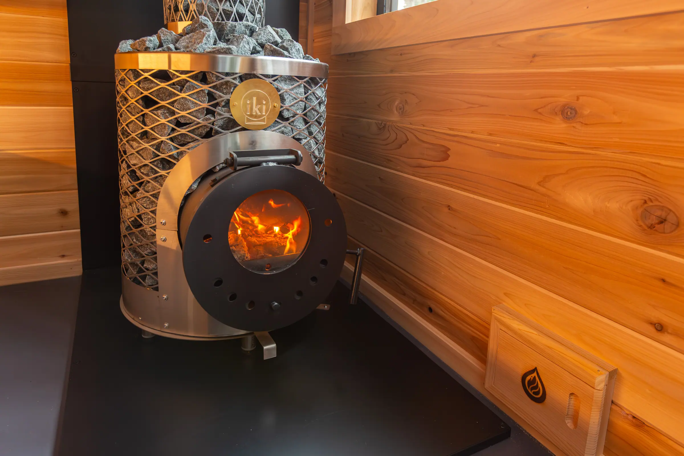Fire in the round door of a wood-fired IKI stove